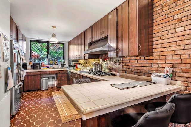 kitchen with tile countertops, a peninsula, extractor fan, and stainless steel appliances