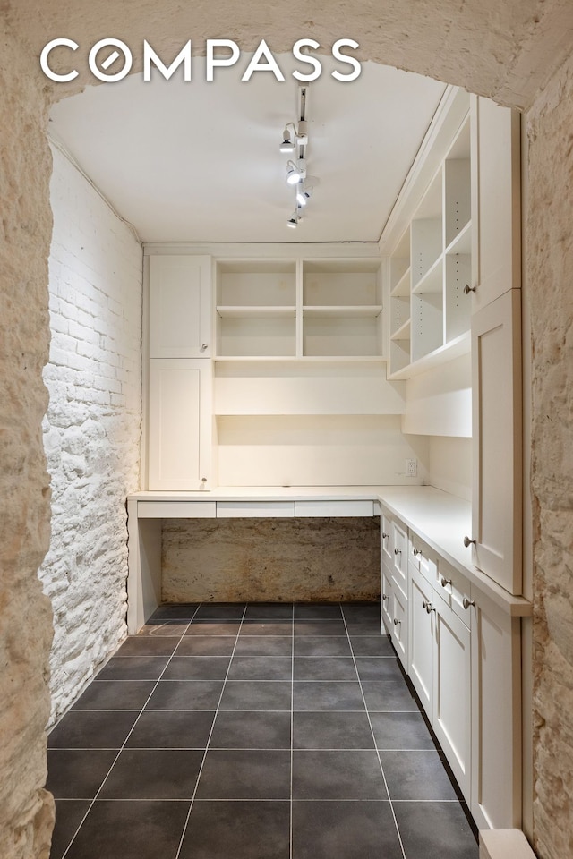 kitchen with open shelves, dark tile patterned flooring, light countertops, and white cabinets