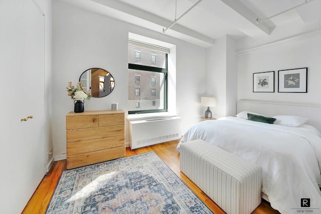 bedroom featuring light wood-style floors and radiator heating unit