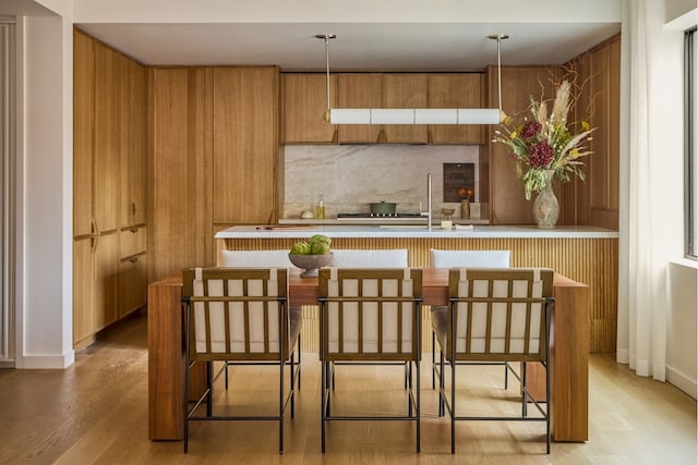 323 Bergen St Unit Th114E, New York City, NY 11217 - kitchen with brown cabinets, light wood finished floors, light countertops, and decorative backsplash
