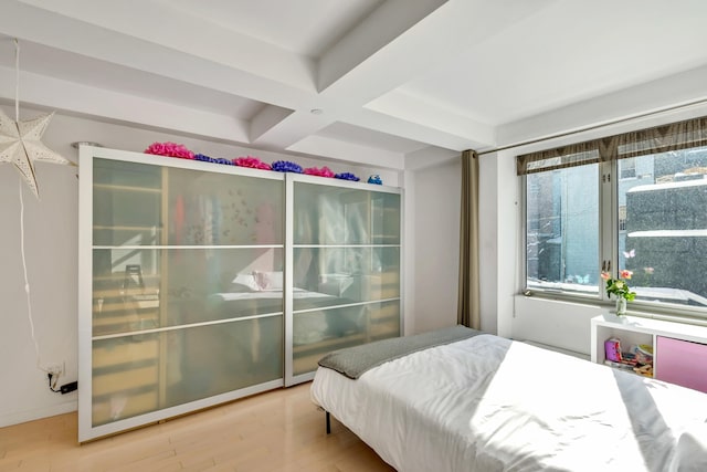 bedroom with beam ceiling, coffered ceiling, and wood finished floors