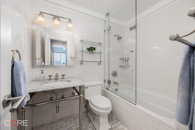 20 E 35th St Unit 2E, New York City, NY 10016 - bathroom with a sink, tile walls, tiled shower / bath combo, toilet, and visible vents