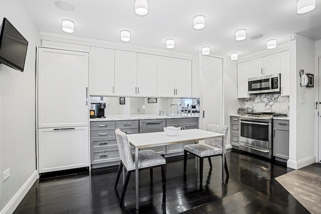 kitchen with gray cabinetry, light countertops, appliances with stainless steel finishes, dark wood-style floors, and tasteful backsplash