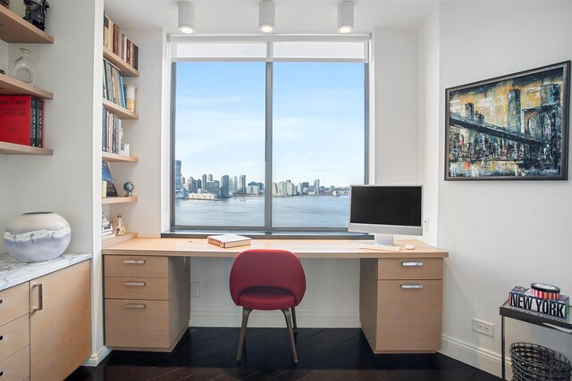 home office with built in study area, healthy amount of natural light, dark wood finished floors, baseboards, and floor to ceiling windows