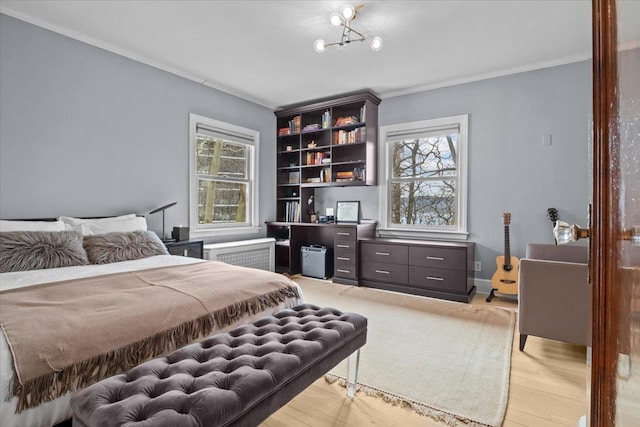 bedroom with multiple windows, crown molding, light wood-style flooring, and radiator heating unit