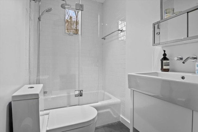 bathroom with shower / bath combination with glass door, vanity, and toilet