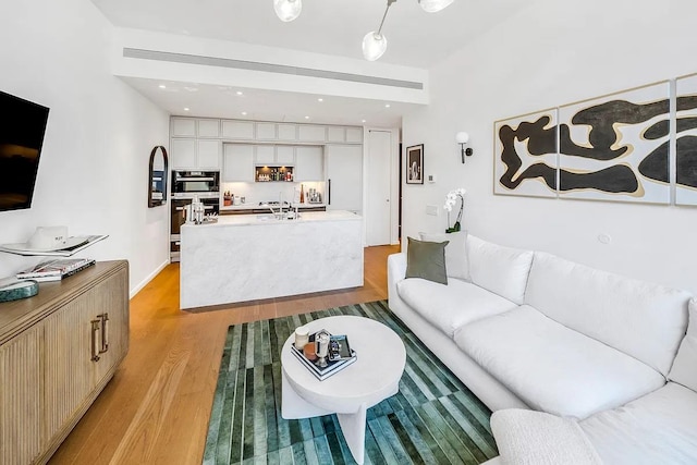 living room with light wood-type flooring and recessed lighting