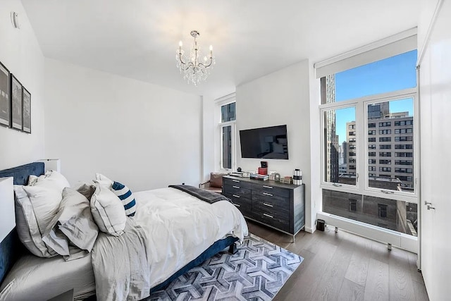 bedroom with dark wood-type flooring and a notable chandelier