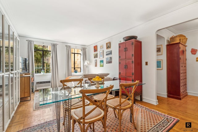 dining space featuring arched walkways, crown molding, and baseboards