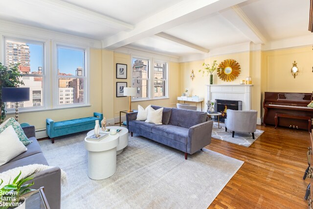 living room featuring a baseboard heating unit, a brick fireplace, wood finished floors, and beam ceiling