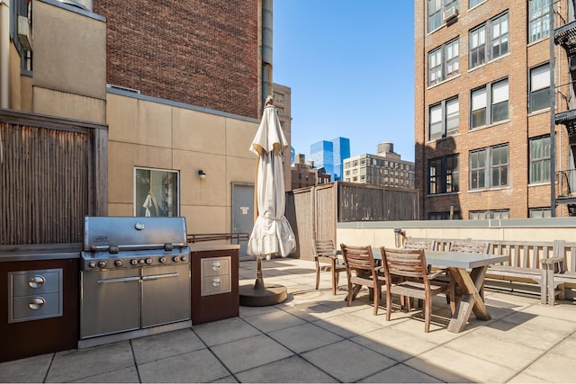 view of patio with a view of city, outdoor dining space, an outdoor kitchen, and area for grilling