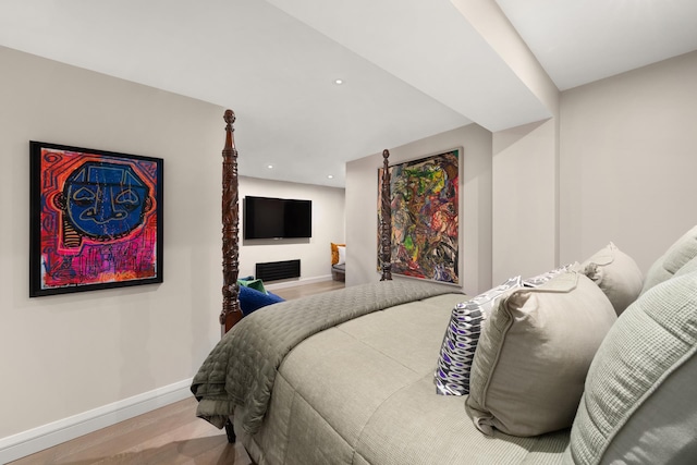 bedroom with baseboards, wood finished floors, and recessed lighting