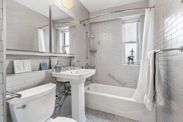 bathroom featuring toilet, shower / tub combo, and tile walls