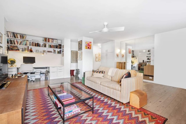 living area with hardwood / wood-style flooring and a ceiling fan