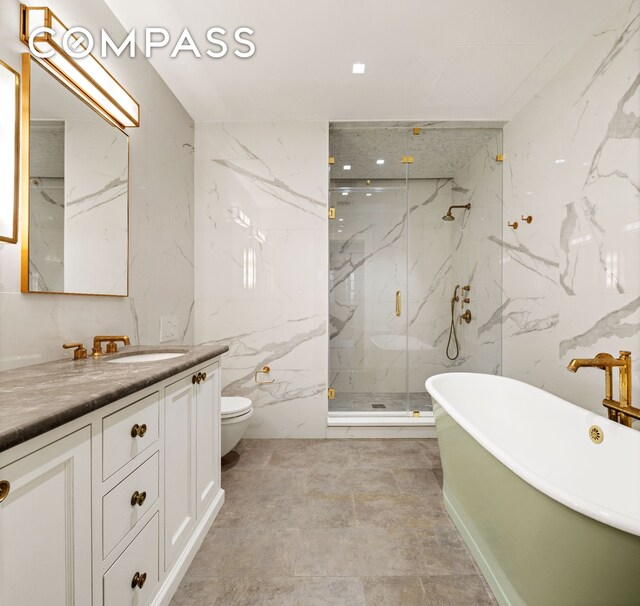 full bath featuring a marble finish shower, toilet, stone wall, and vanity