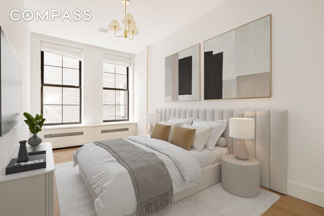 bedroom with visible vents, a notable chandelier, and light wood-style flooring