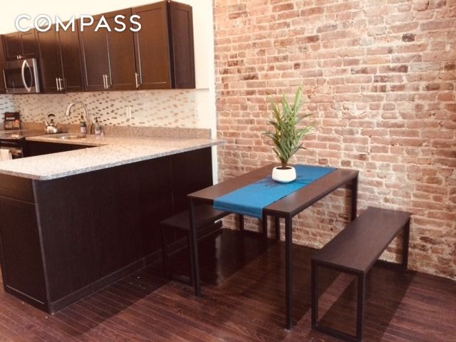 kitchen with stainless steel microwave, decorative backsplash, and dark wood-style flooring