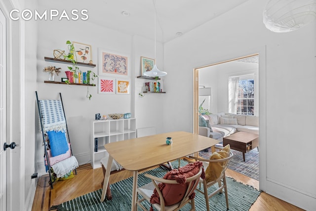 dining space with baseboards and wood finished floors