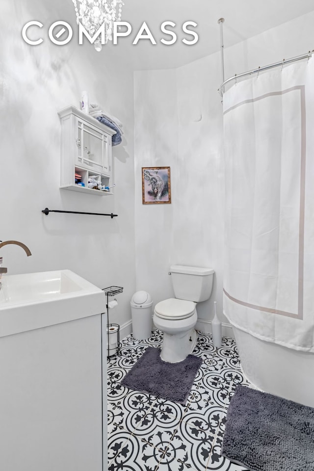 full bath featuring curtained shower, toilet, vanity, and tile patterned flooring