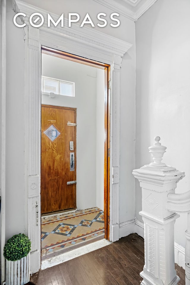 entryway featuring wood-type flooring and ornamental molding