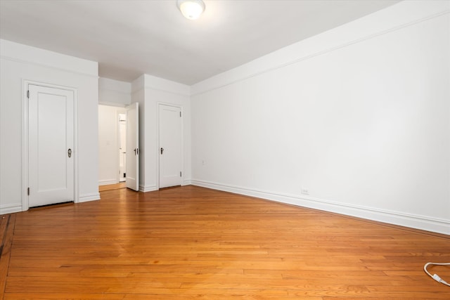 spare room with light wood-style floors and baseboards