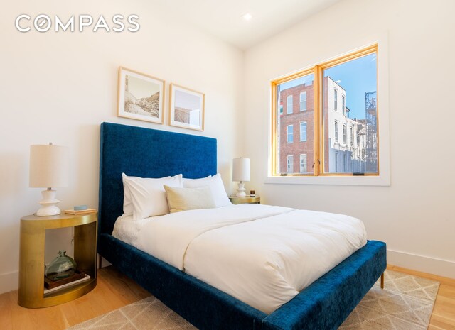 bedroom with recessed lighting, wood finished floors, and baseboards