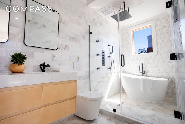 full bath featuring marble finish floor, a shower stall, tile walls, and vanity