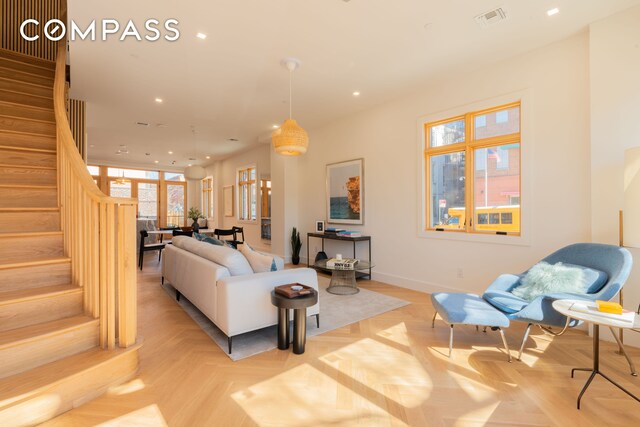 living area featuring recessed lighting, visible vents, and stairway