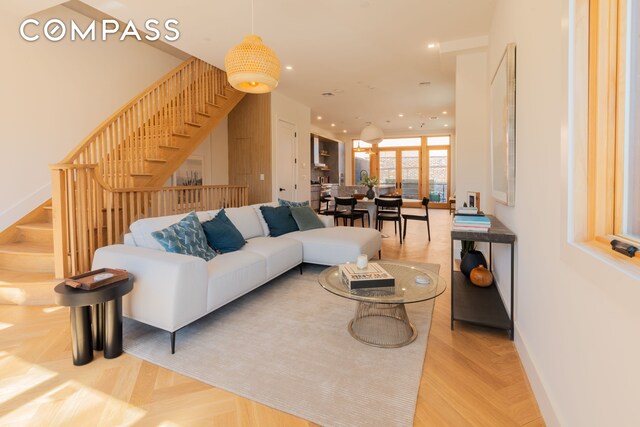 living room featuring baseboards, stairway, and recessed lighting