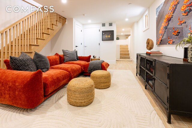 living area with stairs, light wood-type flooring, and recessed lighting