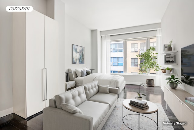 living area featuring baseboards and dark wood-style flooring