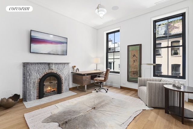 office with plenty of natural light, wood finished floors, visible vents, and a high end fireplace