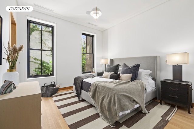 bedroom with light wood-style flooring and visible vents