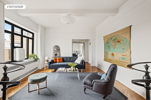 living room with baseboards, radiator heating unit, visible vents, and beam ceiling