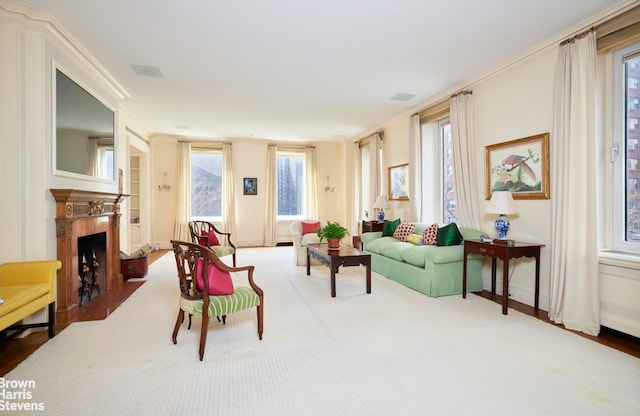 living area with crown molding, visible vents, and a fireplace