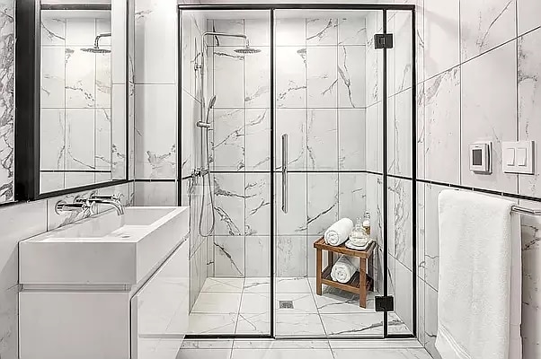 full bathroom with vanity, a shower stall, and tile walls