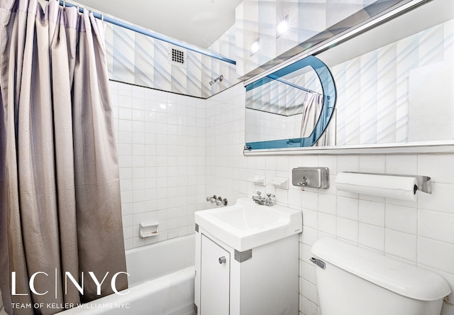 bathroom featuring tasteful backsplash, toilet, shower / bath combo with shower curtain, vanity, and tile walls