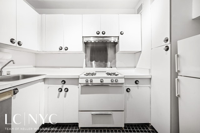 kitchen featuring light countertops, visible vents, white cabinetry, a sink, and white appliances