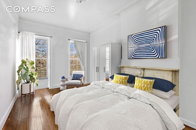 bedroom with ornamental molding, baseboards, and hardwood / wood-style floors