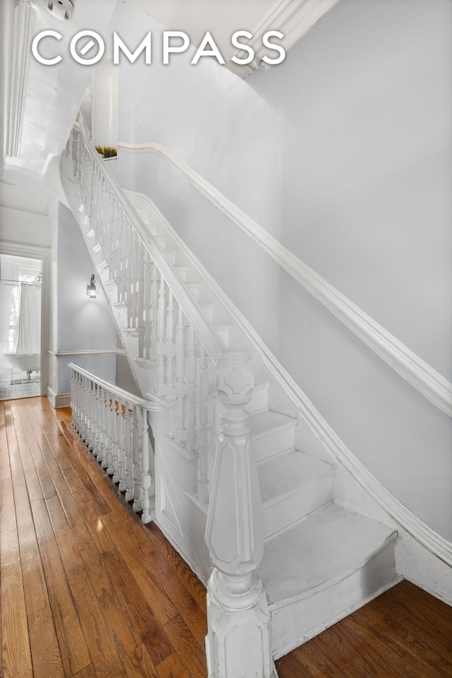 stairway featuring baseboards and hardwood / wood-style floors