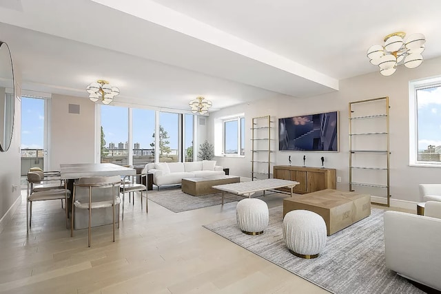 living area with a chandelier, wood finished floors, visible vents, and baseboards