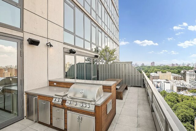 view of patio featuring a city view, a grill, a balcony, and area for grilling