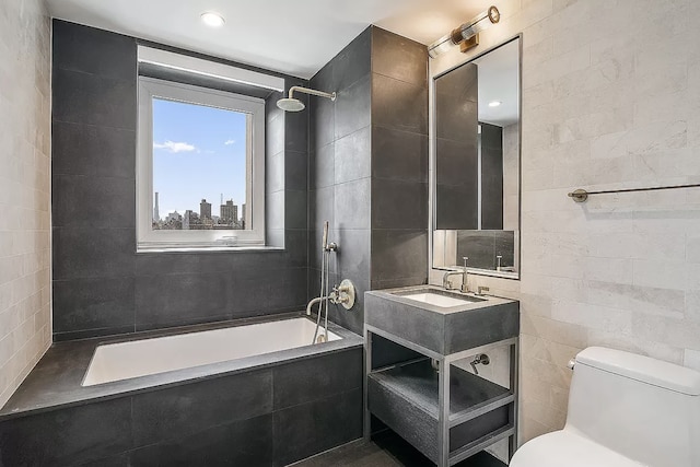 full bath with toilet, tiled shower / bath combo, vanity, and tile walls