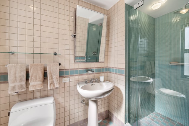 full bathroom featuring toilet, tile walls, and a shower stall