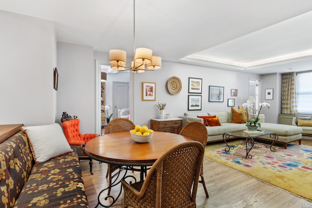 dining area featuring light wood-style floors and an inviting chandelier