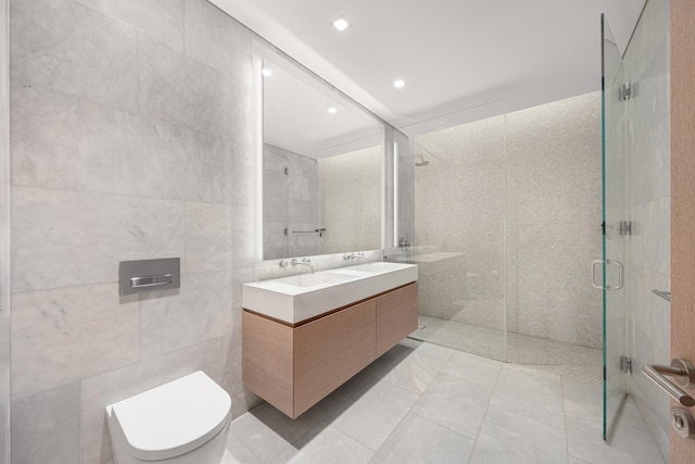 bathroom featuring double vanity, a stall shower, toilet, tile walls, and recessed lighting