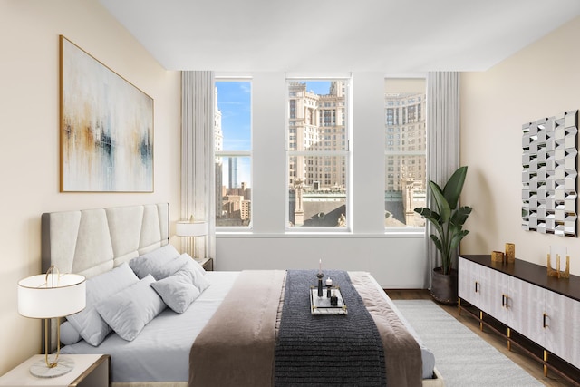 bedroom featuring wood finished floors and a city view