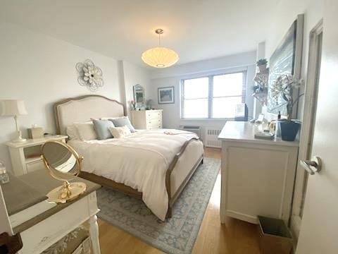 bedroom with light wood-type flooring and radiator