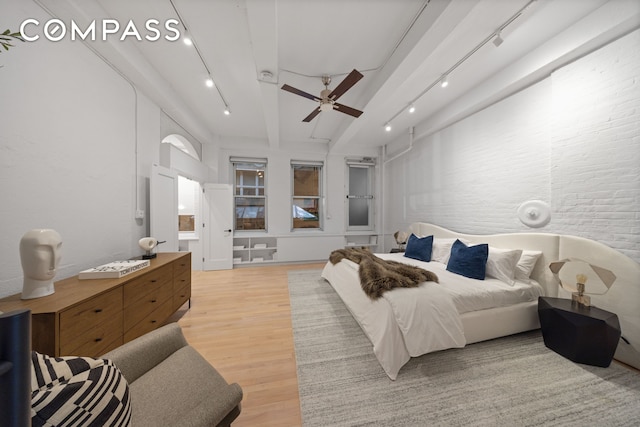 bedroom featuring light wood-type flooring, beamed ceiling, ceiling fan, and track lighting