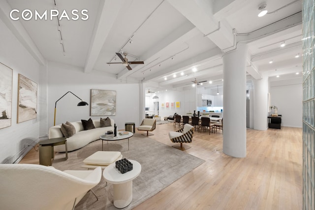 living area featuring ceiling fan, beamed ceiling, light wood-type flooring, and rail lighting
